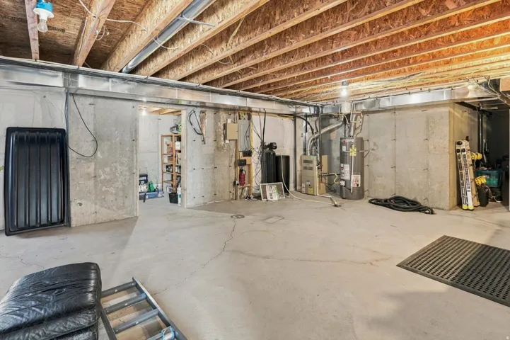 Unfinished basement with concrete flooring and exposed ceiling joists
