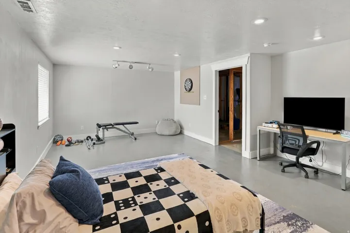 Spacious interior with light gray walls, recessed lighting, and a window with white blinds