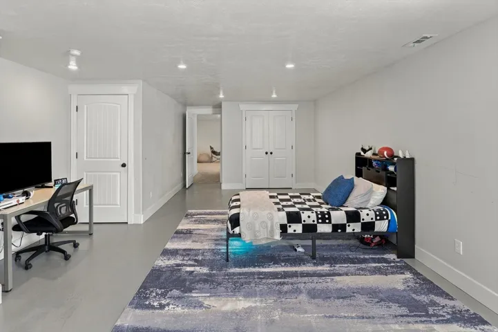 Spacious room featuring light gray walls, recessed lighting, and a neutral flooring
