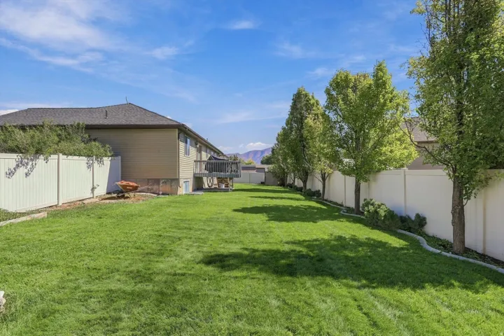 Expansive lawn with mature trees and perimeter fencing