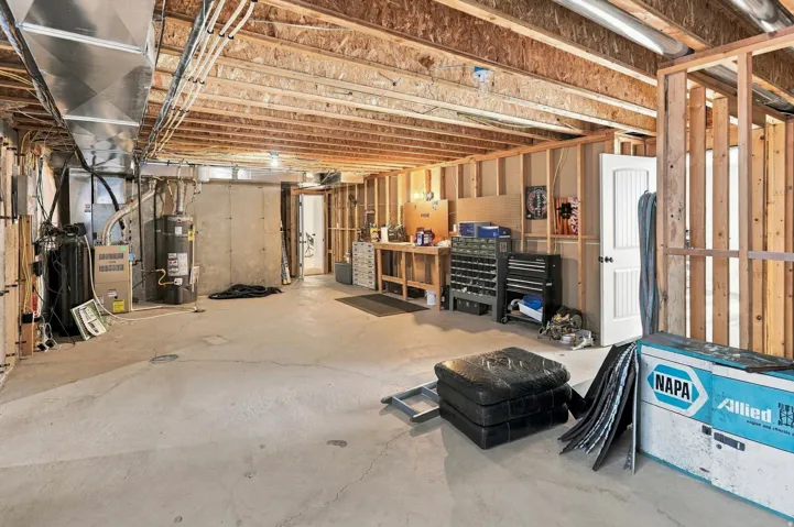 Unfinished basement featuring exposed wood framing, concrete flooring, and visible ductwork