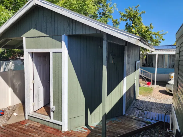 Outdoor storage structure with a gabled roofline and board-and-batten siding