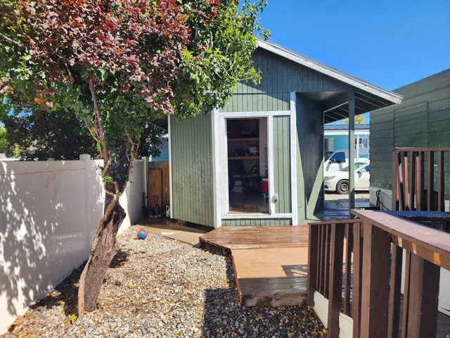 Detached storage building with a wood-plank exterior and covered entry