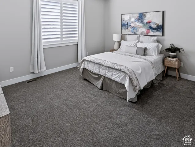 Full-height window with white plantation shutters, gray wall paint, and gray carpeting