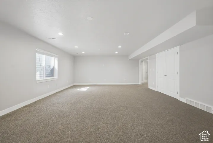 Carpeted room with a window, recessed lighting, and white bi-fold doors