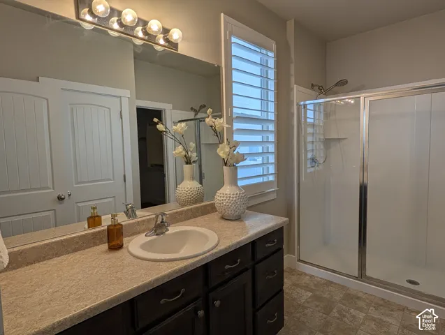 Single vanity with an integrated sink, dark wood-finish cabinetry, and a large mirror