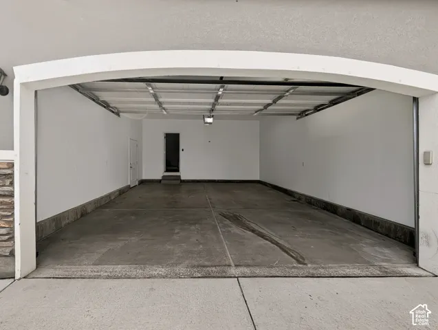 Spacious garage with concrete flooring, painted walls, and overhead lighting