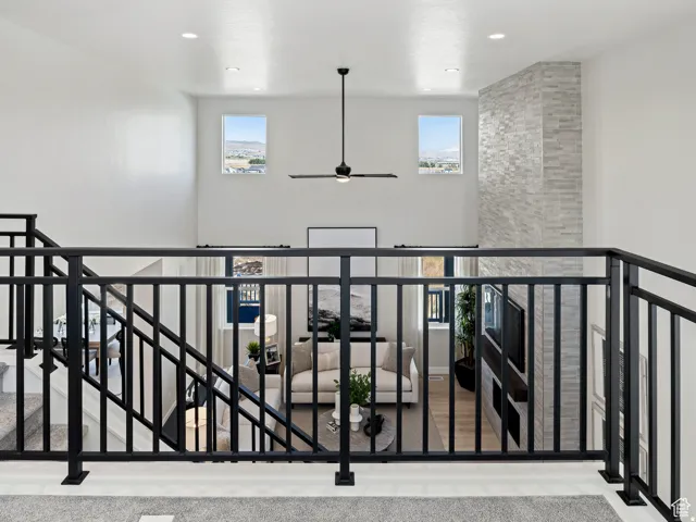 Open-concept living space with a soaring ceiling, recessed lighting, and a modern ceiling fan