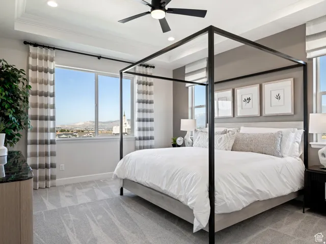 Tray ceiling with recessed lighting, ceiling fan, expansive windows, gray wall color, and carpeted flooring