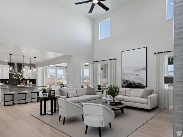 High ceilings with upper windows, wood-finish flooring, recessed lighting, and a kitchen island with pendant lighting