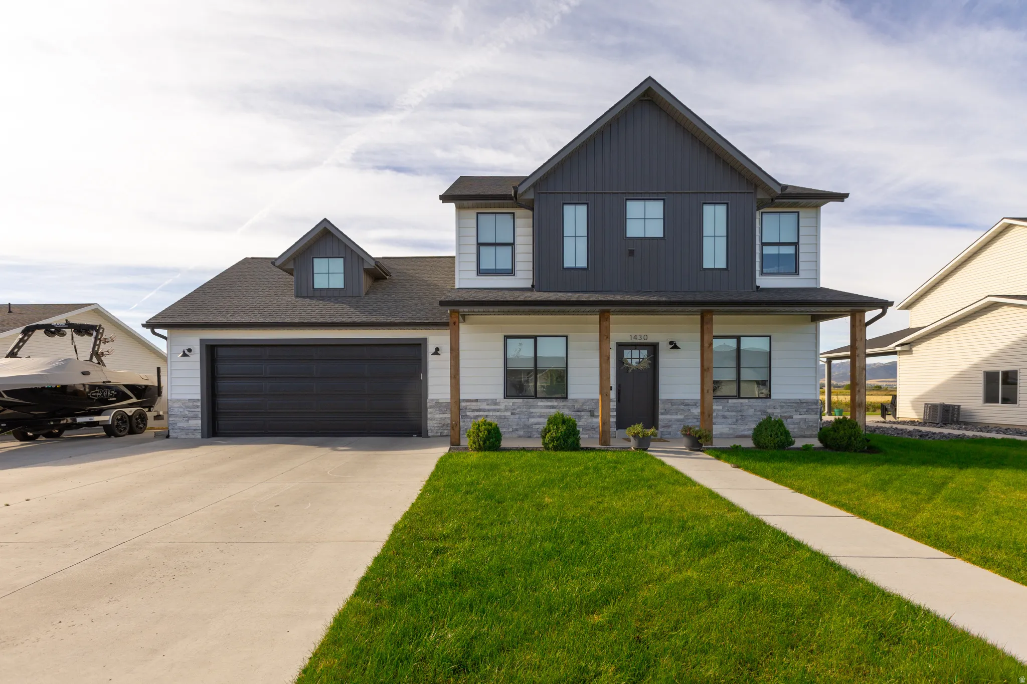 Contemporary two-story exterior with vertical siding accents, stone veneer detailing, and a covered porch