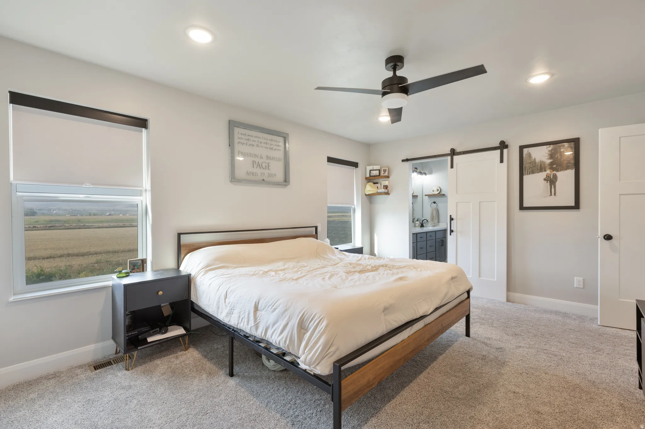 Recessed lighting, ceiling fan with light, barn door entry, window with roller shade, and carpet flooring