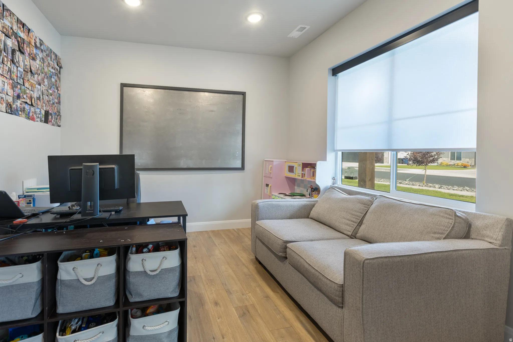 Recessed ceiling lighting, wood-finish flooring, and a large window with roller shade