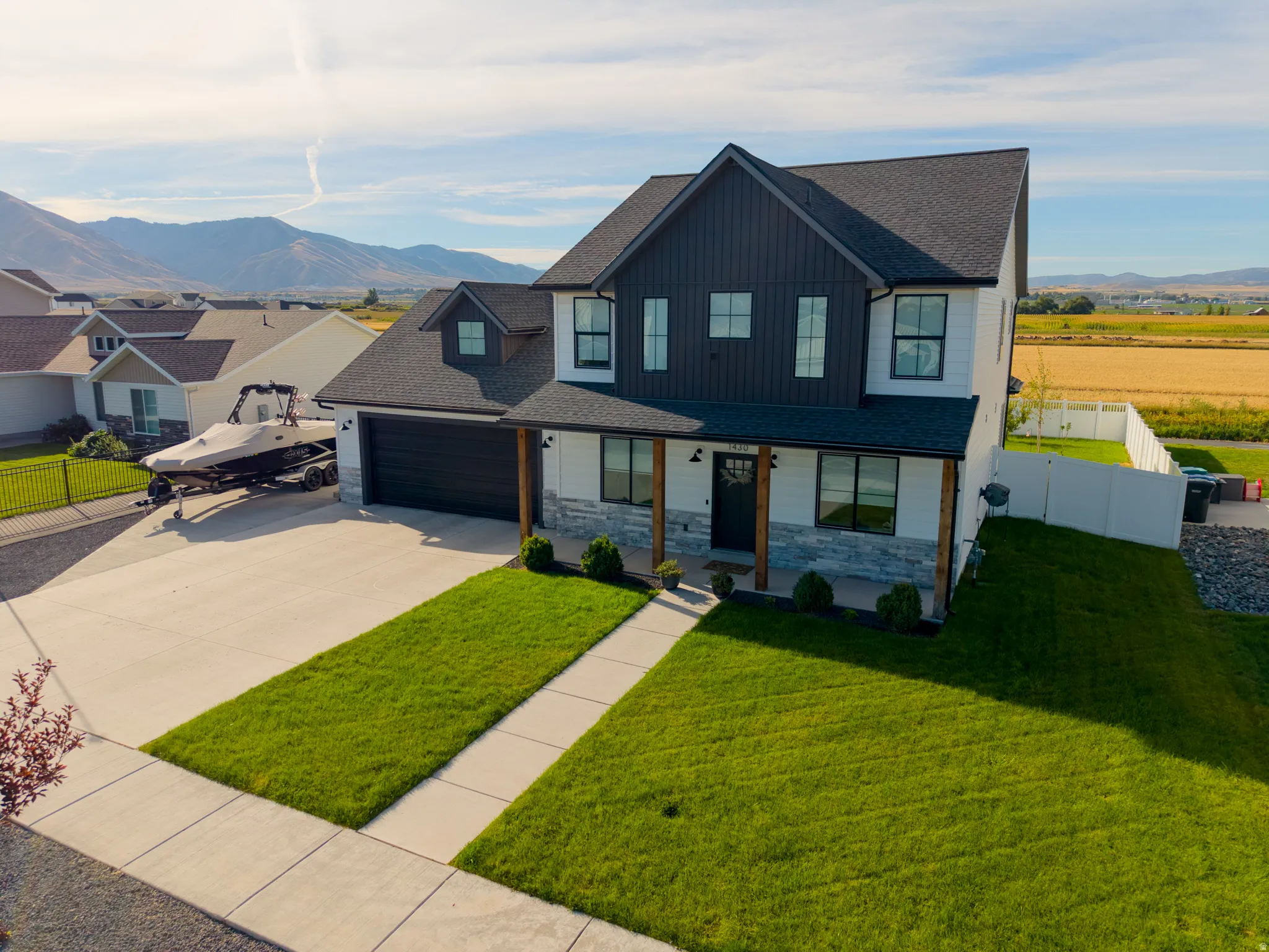 Modern farmhouse exterior with white vertical siding and dark board and batten accents