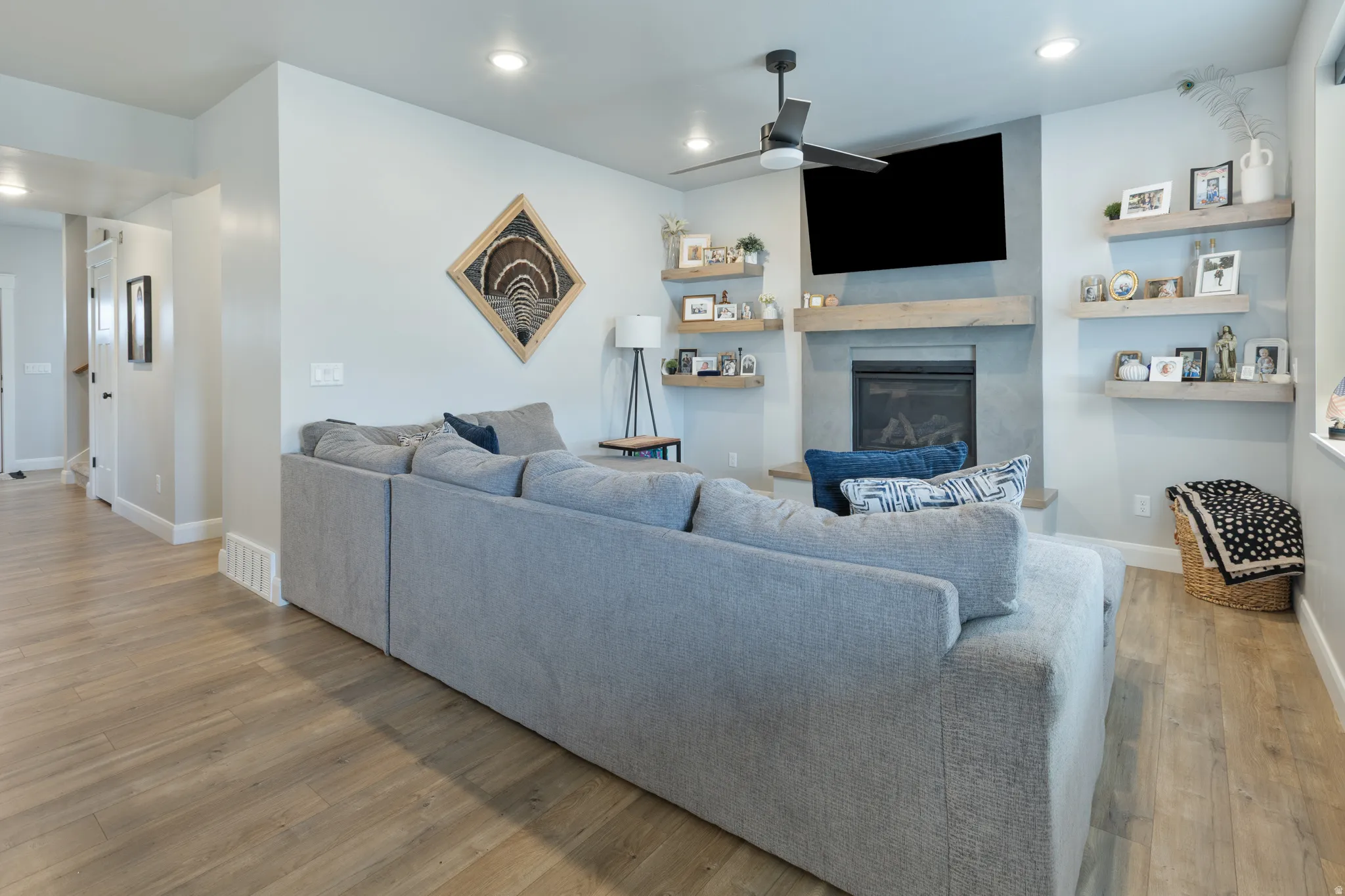 Recessed lighting, wood-finish flooring, and a ceiling fan with integrated lighting