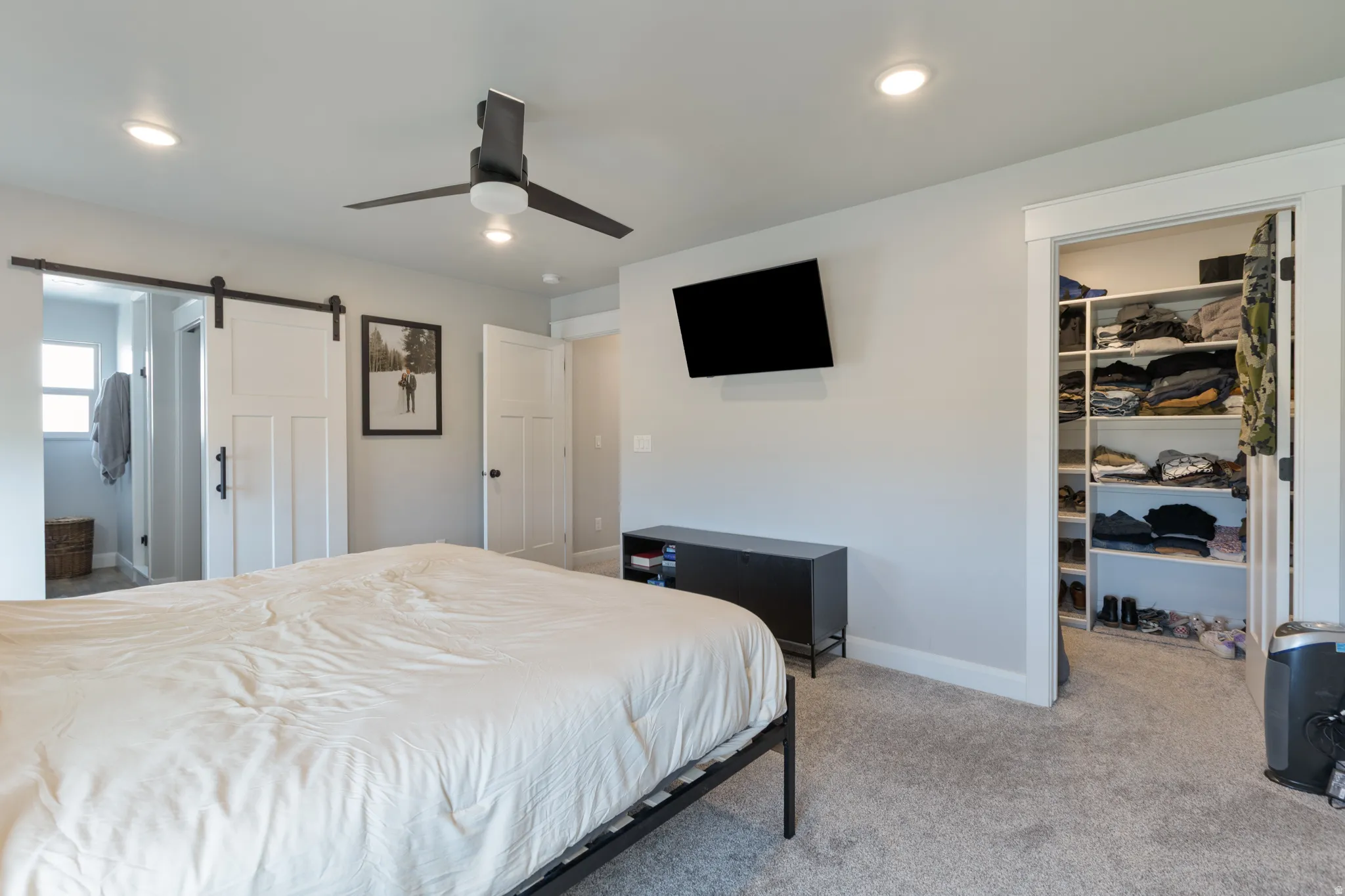 Recessed lighting, ceiling fan, carpet flooring, and a walk-in closet with built-in shelving