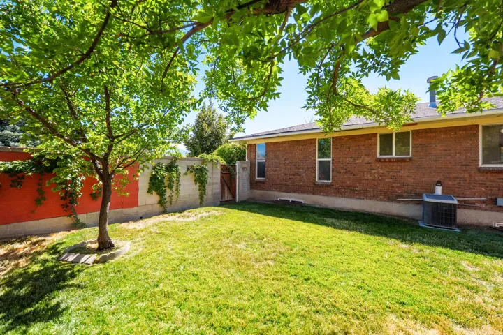 Expansive lawn with mature trees and a brick exterior