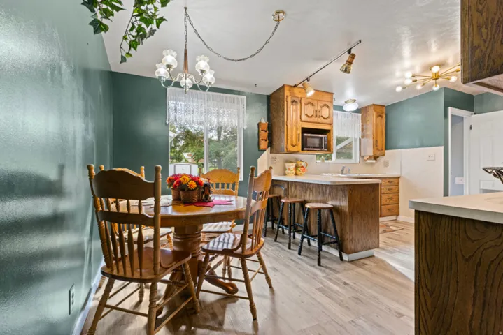Kitchen with wood-finish flooring, built-in cabinetry, an integrated microwave, and track lighting