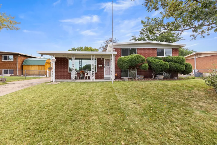 Brick home with a covered front porch entry, a garage, and an extended driveway