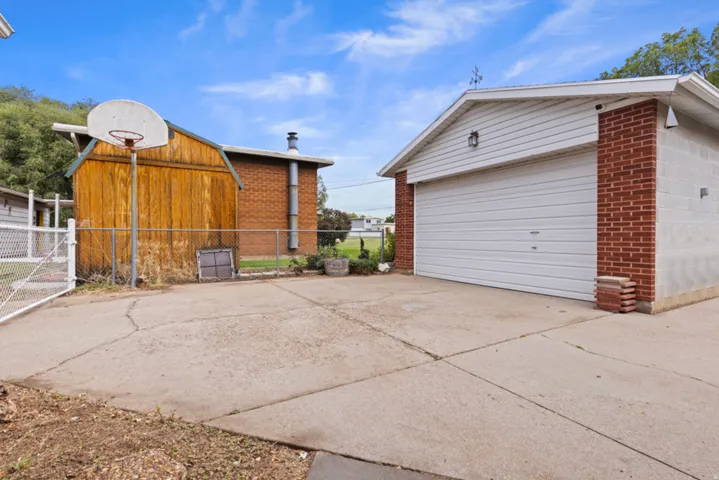 Concrete driveway providing access to a two-car garage with a white roll-up door