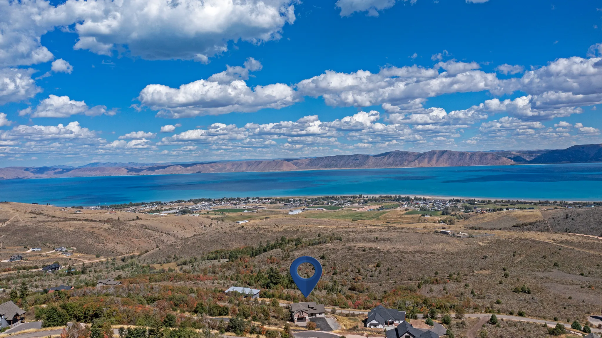 Expansive elevated property featuring a clear lake and distant mountain range