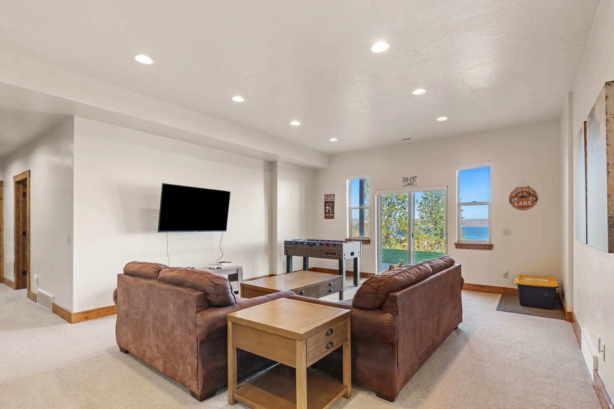 Spacious room with recessed lighting, light-toned carpeting, and wood-finish trim