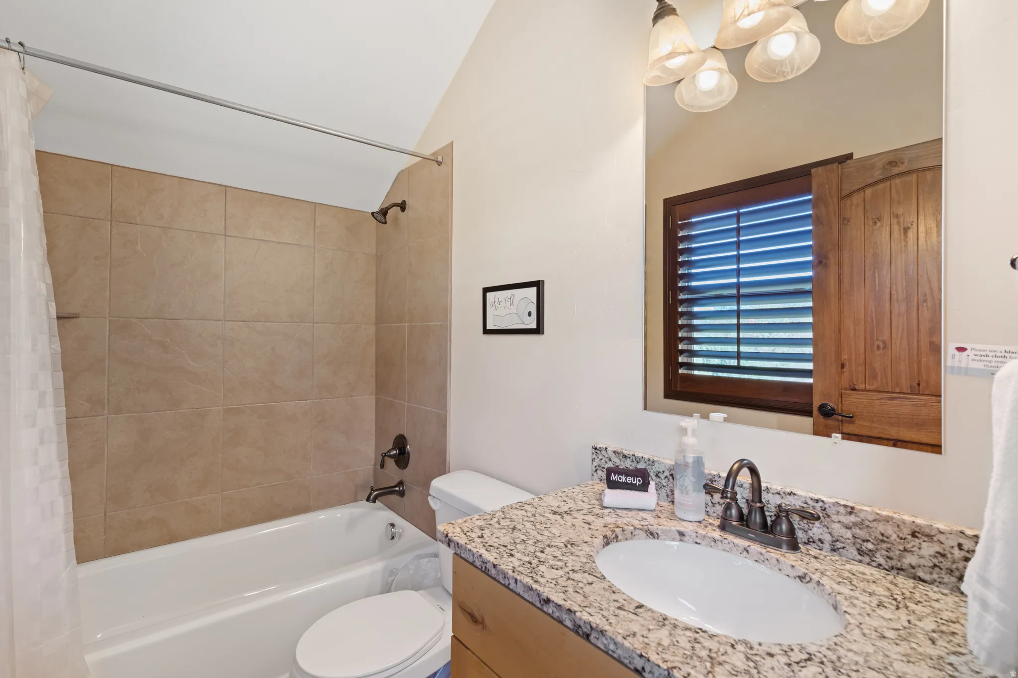 Bathroom featuring a vanity with a granite-style countertop, undermount sink, and dark bronze-finish fixtures