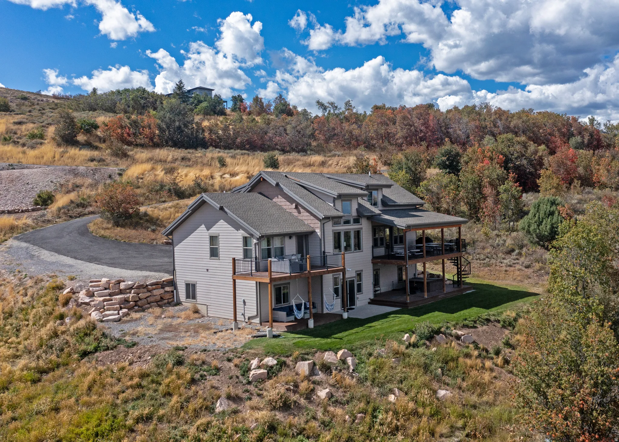 Multi-level residence featuring extensive outdoor decking, a covered patio, and a manicured lawn