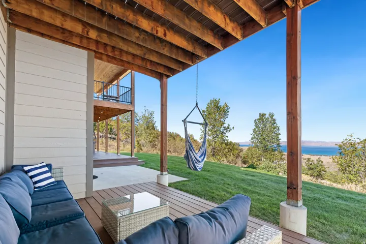 Covered patio with wood-finish decking, exposed wood beam ceiling, and a concrete slab foundation