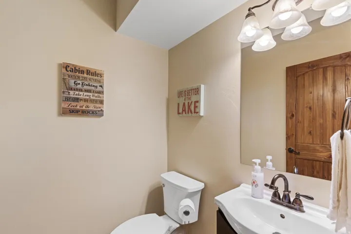 Pedestal vanity with an integrated basin, bronze-finish faucet, and a wall-mounted mirror