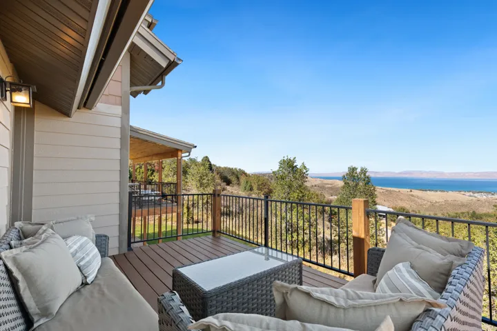 Expansive outdoor deck with composite decking, iron railing, and distant water scenery