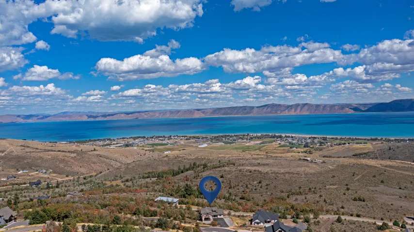 Expansive elevated property featuring a clear lake and distant mountain range