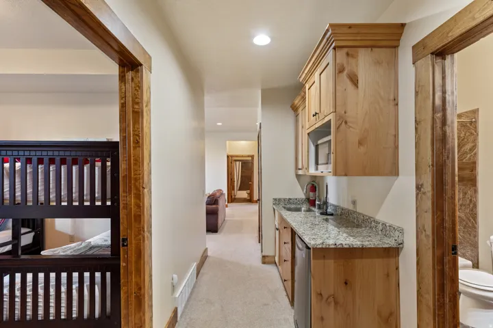 Kitchenette with light wood-finish cabinetry, speckled countertop, and built-in sink