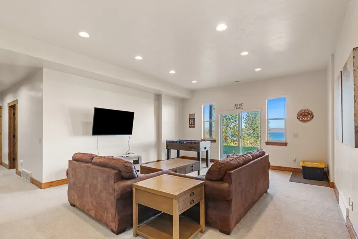 Spacious room with recessed lighting, light-toned carpeting, and wood-finish trim