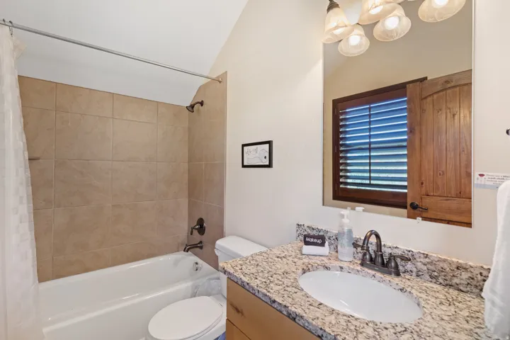 Bathroom featuring a vanity with a granite-style countertop, undermount sink, and dark bronze-finish fixtures