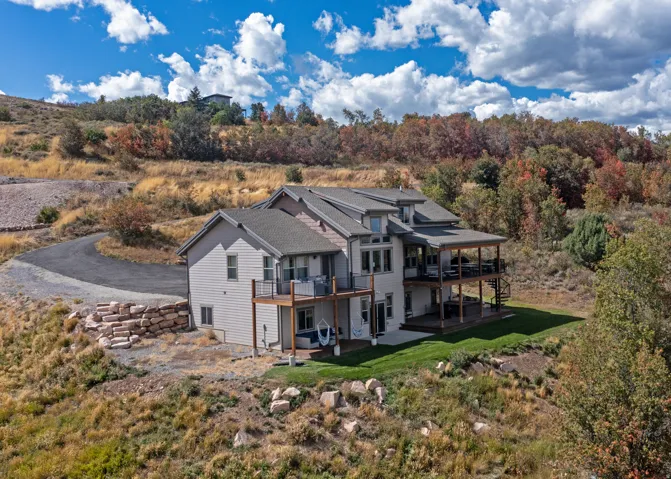 Multi-level residence featuring extensive outdoor decking, a covered patio, and a manicured lawn