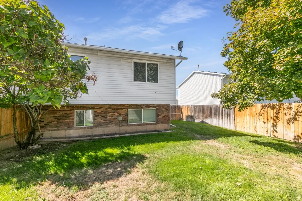 Expansive lawn area with mature trees and wood fencing