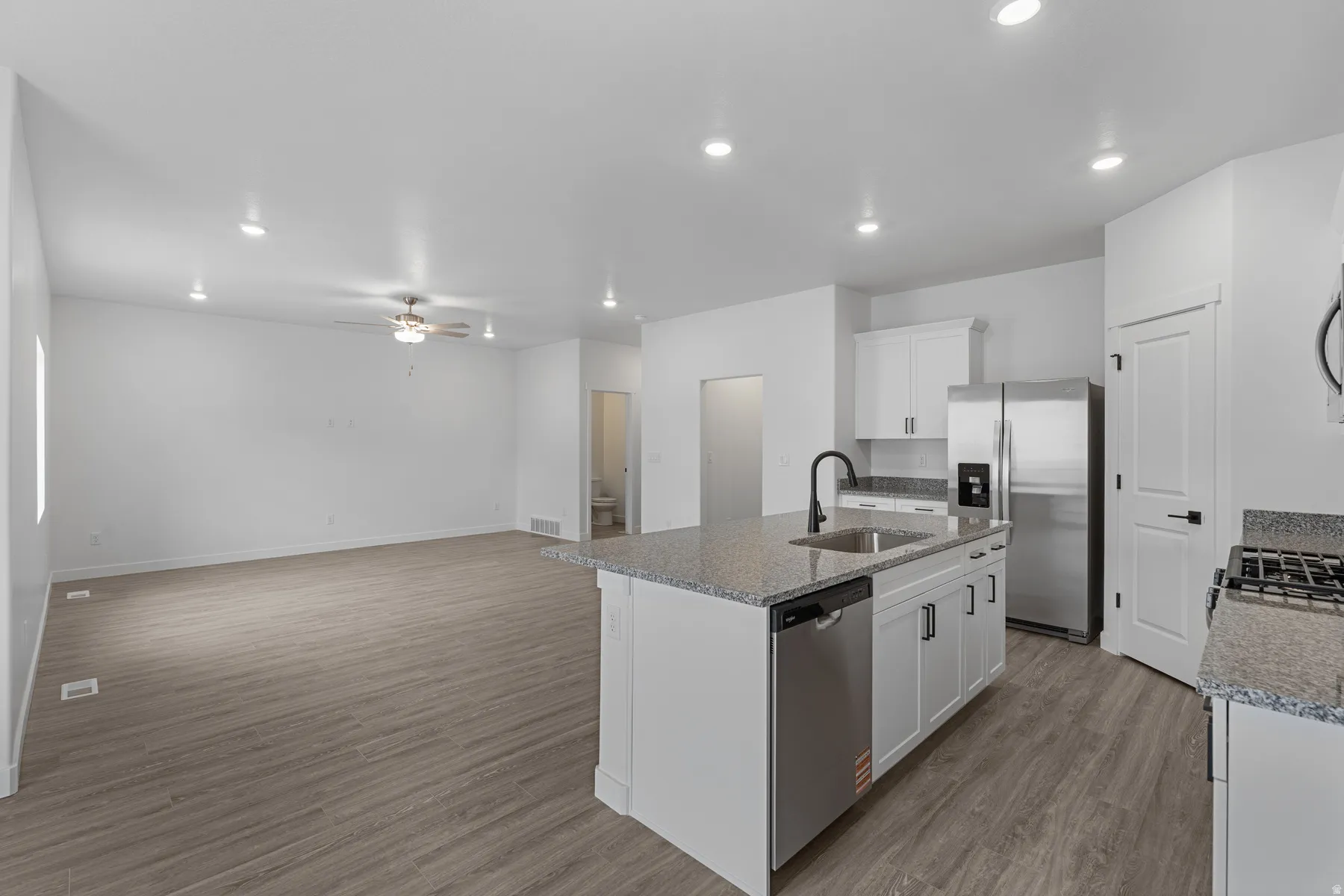 Open-concept living space featuring wood-finish flooring and recessed lighting