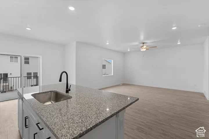 Kitchen island with a stainless steel sink, black faucet, and granite countertop