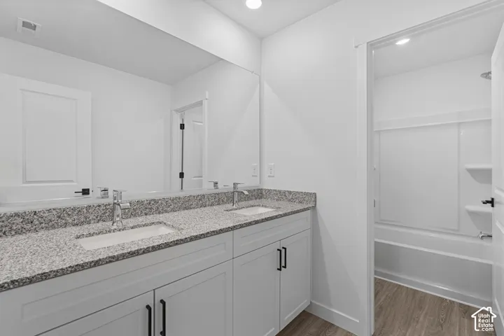 Dual vanity with a stone-finish countertop, under-mount sinks, and chrome fixtures