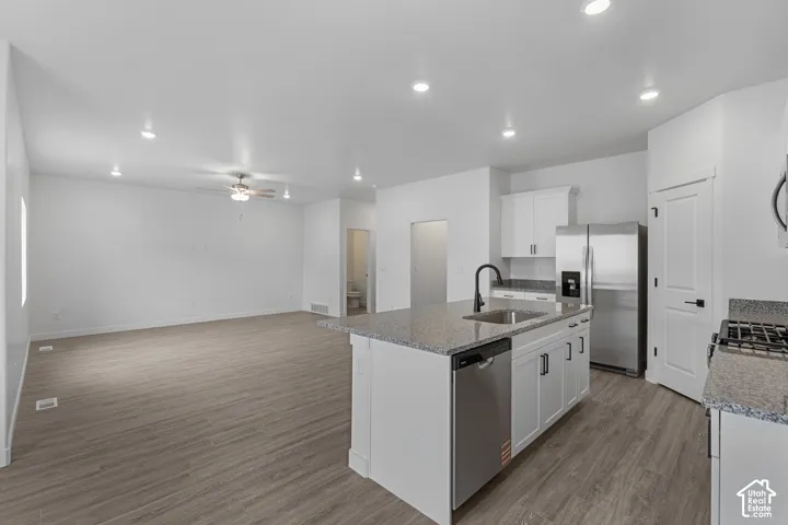 Open-concept living space featuring wood-finish flooring and recessed lighting
