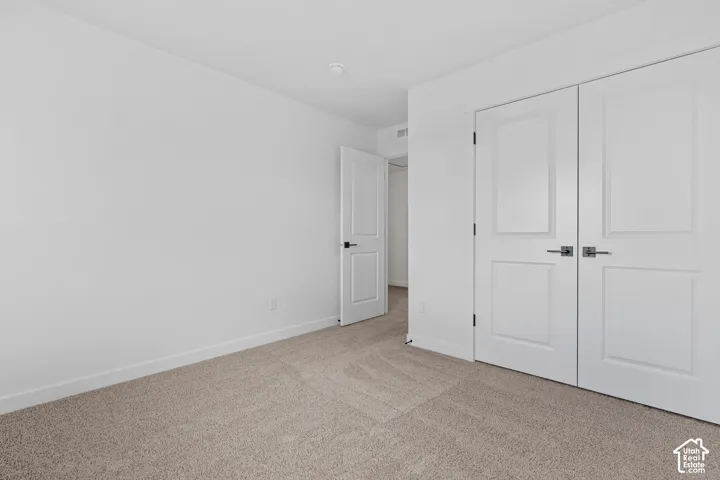 Neutral-toned carpet flooring and white walls