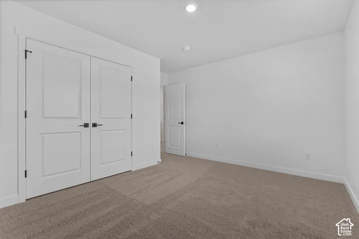 Neutral wall palette, recessed lighting, and soft carpet flooring