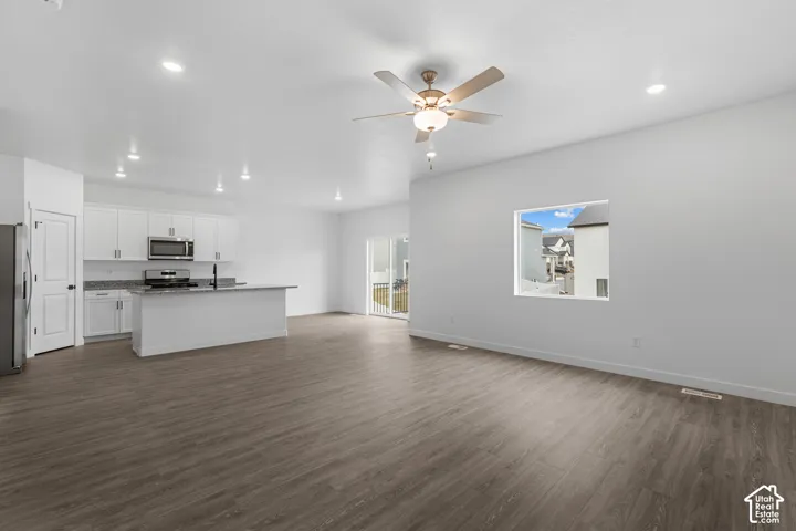 Open-concept living area featuring wood-finish flooring, recessed lighting, and a ceiling fan