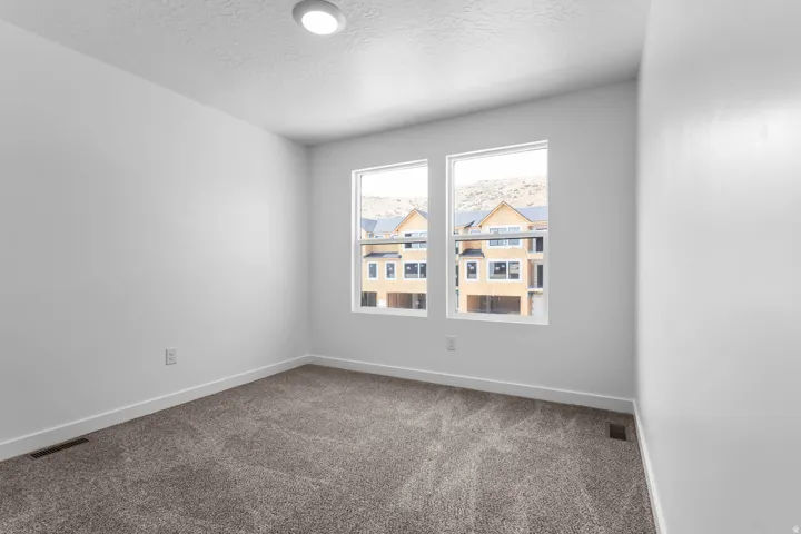 Two large windows, recessed ceiling light, and neutral wall color