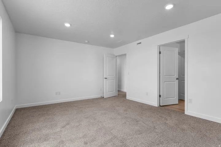 Plush carpeting, recessed lighting, white interior doors, and a neutral color palette