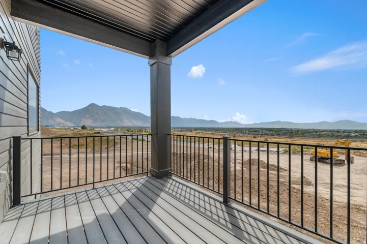 Covered balcony featuring composite decking and black metal railings