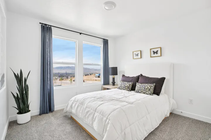 White walls, carpet flooring, and large windows with mountain scenery