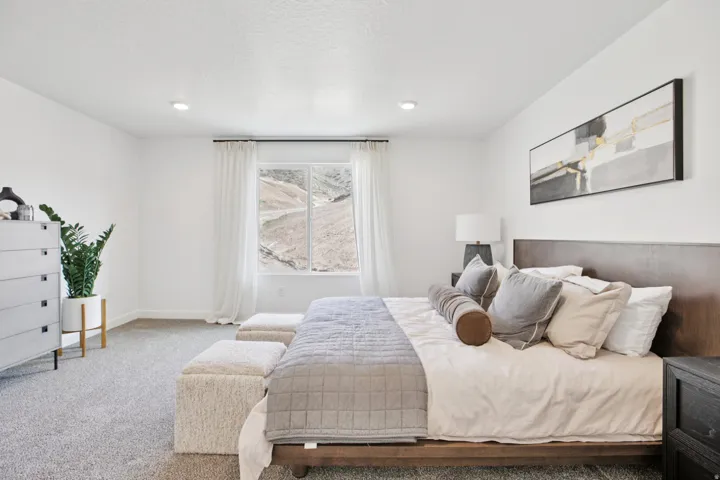 Recessed lighting, large window with mountain backdrop, neutral wall color, and carpeted flooring