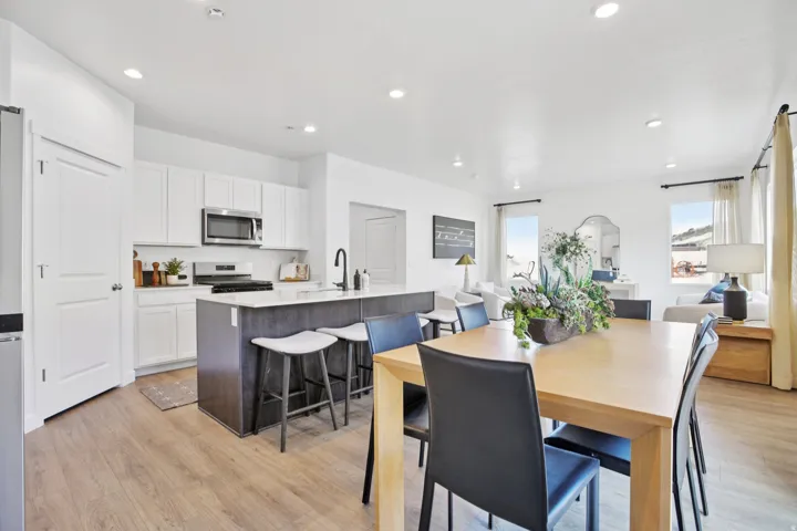 Open-concept living space with wood-finish flooring, recessed lighting, and multiple windows